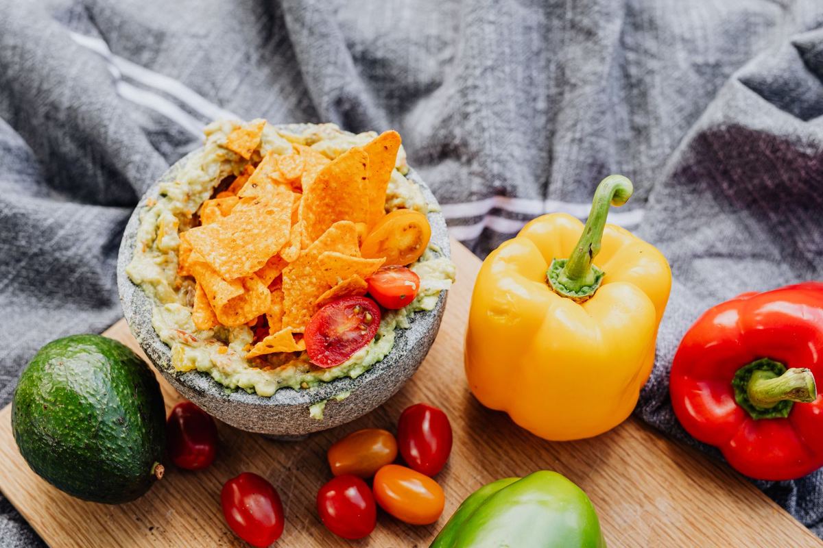 Guacamole con totopos junto a verduras frescas